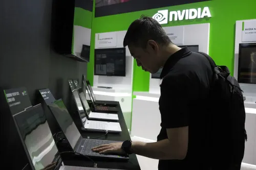 رجل يتفاعل مع أجهزة كمبيوتر محمولة في جناح شركة إنفيديا، مع التركيز على تقنيات الذكاء الاصطناعي والرقائق الحديثة.