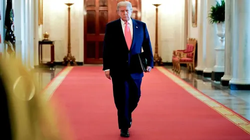 رجل يرتدي بدلة رسمية يسير في ممر مزين بالسجاد الأحمر داخل مبنى حكومي، يعكس أجواء السياسة الأمريكية الحالية.