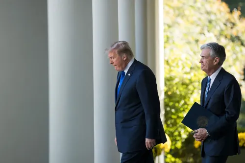 ترامب وجيروم باول يسيران في حديقة البيت الأبيض، بعد إقالة ليزا كوك من مجلس الاحتياطي الفيدرالي، مما يؤثر على الأسواق المالية.