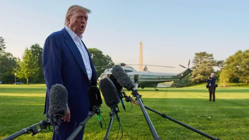 دونالد ترامب يتحدث للصحفيين أمام المروحية الرئاسية في حديقة البيت الأبيض، مع وجود معالم واشنطن في الخلفية.