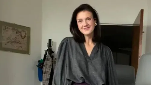 موظفة في مكتب إدارة شؤون الموظفين ترتدي ملابس أنيقة وتبتسم للكاميرا، مع تفاصيل عن نشاطها كمؤثرة في الموضة على إنستغرام.