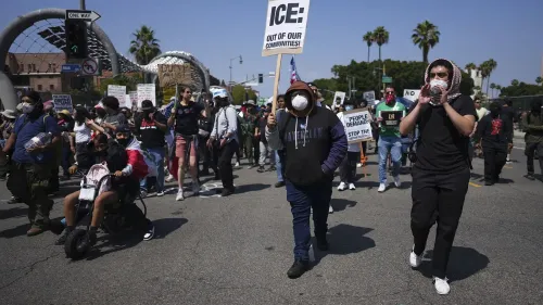 احتجاجات في لوس أنجلوس، حيث يتظاهر المتظاهرون ضد قوانين الهجرة، حاملين لافتات تطالب بإلغاء سياسة ICE.