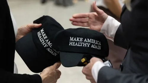 قبعات سوداء مكتوب عليها "اجعلوا أمريكا صحية مرة أخرى" تُظهر تفاعلًا بين المشاركين، تعكس مبادرة ترامب للصحة العامة وسط انتقادات للسياسات الصحية.