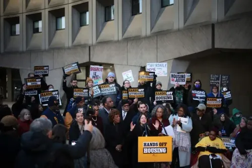 تجمع حشد من الأشخاص في بوسطن يحملون لافتات تطالب بحقوق الإسكان العادل، مع التركيز على أهمية المساكن الميسورة التكلفة.