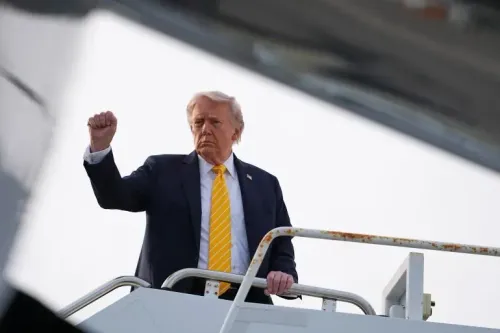 الرئيس الأمريكي دونالد ترامب يرفع يده في إشارة أثناء صعوده على متن طائرة Air Force One، مع خلفية توتر العلاقات مع إيران.