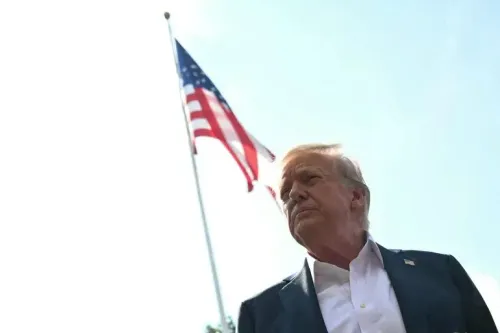 ترامب يقف أمام علم الولايات المتحدة، معبرًا عن قراراته حول التعريفات الجمركية على الواردات من المكسيك والاتحاد الأوروبي.