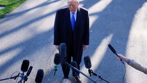 ترامب يتحدث للصحفيين خارج البيت الأبيض، محاطًا بعدد من الميكروفونات، مع التركيز على قضايا ترحيل المهاجرين.