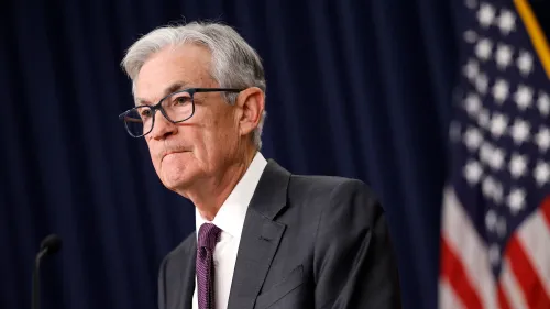 جيروم باول، رئيس مجلس الاحتياطي الفيدرالي، خلال مؤتمر صحفي، مع العلم الأمريكي في الخلفية. يناقش السياسة النقدية وأسعار الفائدة.