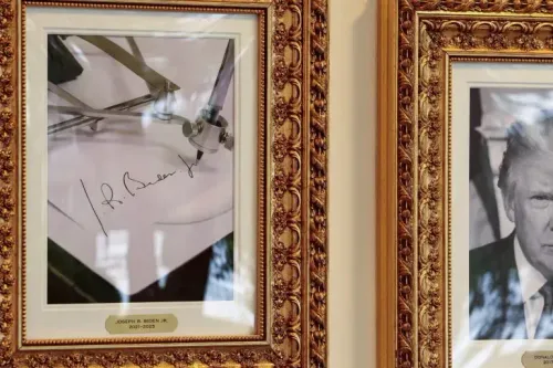 تظهر الصورة توقيع جو بايدن، إلى جانب صورة لدونالد ترامب، في إطار مزخرف. تشير الصورة إلى الجدل حول استخدام بايدن لجهاز الفتح التلقائي.