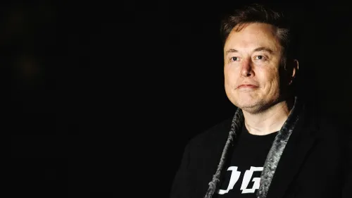 إيلون ماسك في صورة مظلمة، يبدو جادًا أثناء حديثه عن تحديات شركاته، بما في ذلك تسلا وX، وسط ضغوط سياسية واقتصادية.