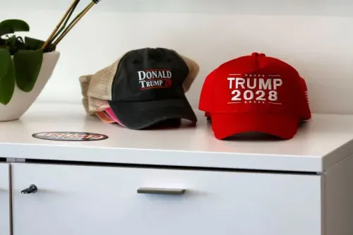 قبعات تحمل شعارات "ترامب 2028" و"دونالد ترامب 2028" موضوعة على مكتب، تعكس طموحات ترامب السياسية المستقبلية.