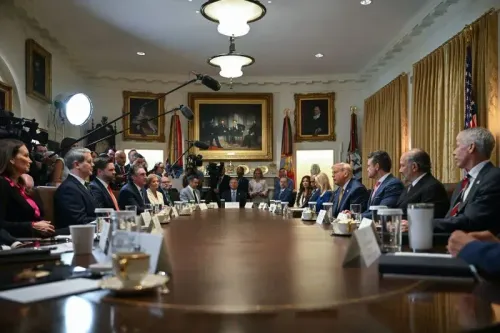 اجتماع لمجلس الوزراء الأمريكي حيث يتواجد الرئيس ترامب مع عدد من المسؤولين، وسط أضواء الكاميرات واللوحات التاريخية.