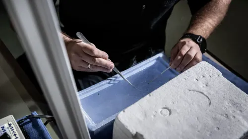 شخص يقوم بإعداد عينات بيولوجية في مختبر، مع التركيز على أدوات الإخصاب في المختبر، مما يعكس جهود تحسين الوصول إلى العلاج.