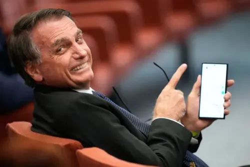 ابتسم الرئيس البرازيلي السابق جايير بولسونارو أثناء جلوسه، ممسكًا بهاتفه المحمول، في سياق توترات سياسية مع الولايات المتحدة.