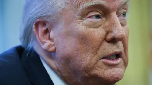 ترامب يتحدث بجدية، مع تعبير وجه يعكس التوتر، أثناء توقيع أمر تنفيذي يؤثر على شركة ويلمر هيل القانونية.