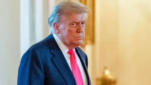 ترامب يبدو عابسًا أثناء مغادرته، مع التركيز على تعبير وجهه الجاد، في سياق تصاعد التوترات القانونية مع وسائل الإعلام حول تقارير الضربات الجوية في إيران.