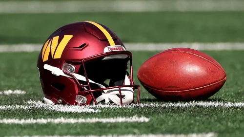 خوذة فريق كرة القدم "كوماندورز" مع كرة قدم أمريكية على أرضية ملعب، تعكس الجدل حول تغيير أسماء الفرق الرياضية في الولايات المتحدة.