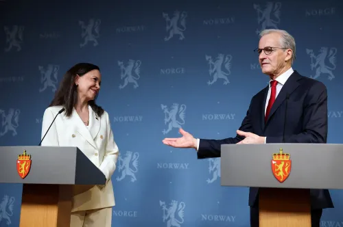 رئيس الوزراء النرويجي يوناس غار ستور يتحدث مع وزيرة الخارجية النرويجية، مع خلفية تحمل شعار النرويج، خلال مؤتمر صحفي.