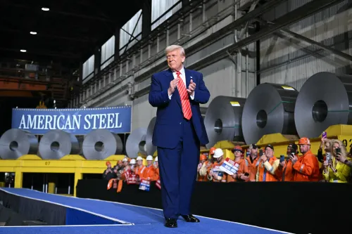 ترامب يتحدث في مصنع للصلب الأمريكي، محاطًا بعمال يرتدون زي العمل، مع لافتة "الصلب الأمريكي" خلفه.