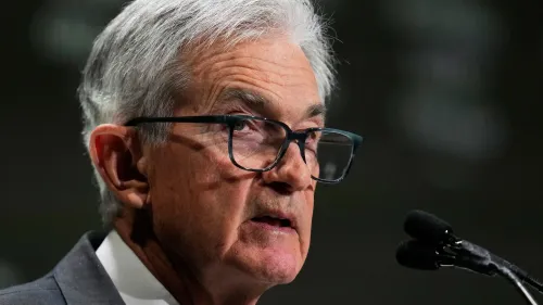 جيروم باول، رئيس الاحتياطي الفيدرالي، يتحدث خلال مؤتمر، مع تعبيرات جادة تعكس التوترات الاقتصادية الحالية.
