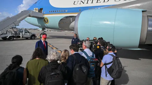 ترامب يتحدث مع الصحفيين أمام طائرة "الولايات المتحدة" أثناء تجمع صحفي، وسط توترات مع وسائل الإعلام التقليدية.