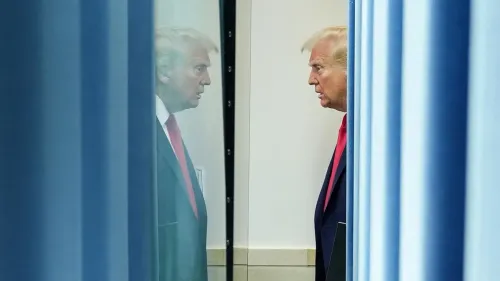 صورة للرئيس دونالد ترامب يراقب نفسه في المرآة وسط أجواء رسمية، تعكس توتر الأوضاع بعد إعلان الرسوم الجمركية الجديدة.