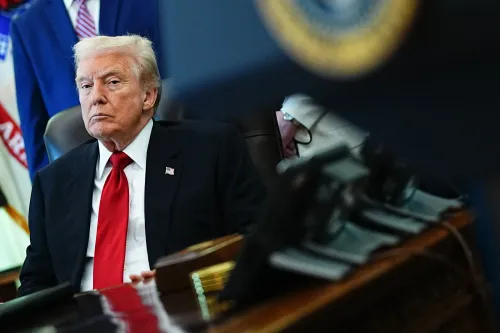 صورة تظهر الرئيس الأمريكي السابق دونالد ترامب جالسًا في المكتب البيضاوي، مع تعبير جاد، بينما يظهر جزء من العلم الأمريكي خلفه.