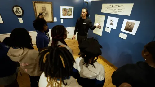 مجموعة من الأطفال يستمعون إلى مرشد في متحف التاريخ الأمريكي الأفريقي في بوسطن، حيث يتعلمون عن تاريخ إلغاء العبودية.