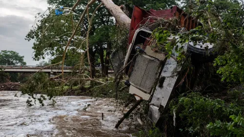 شاحنة مقلوبة وسط الفيضانات في تكساس، مع شجرة متساقطة، تعكس الأضرار الناتجة عن الكارثة الطبيعية وتأثيرها على المجتمع.