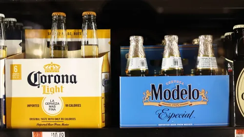 عبوات بيرة كورونا لايت وموديلو إسبشال على رف في متجر، تعكس تأثير سياسات الهجرة على مبيعات البيرة بين المجتمع اللاتيني.