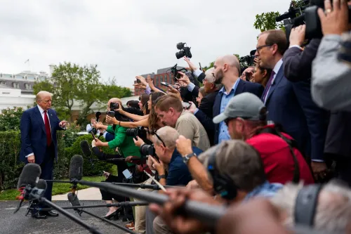 الرئيس ترامب يتحدث إلى الصحفيين وسط حشد كبير من المصورين والإعلاميين، مع التركيز على قضايا الاقتصاد وإحصاءات العمل.