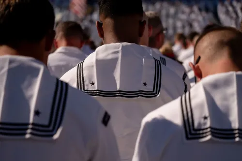 جنود بحريين يرتدون زيهم الرسمي، يظهرون من الخلف في تجمع رسمي، مما يعكس أهمية دعم القوات خلال الإغلاق الحكومي.