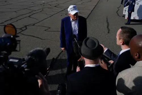 ترامب يتحدث إلى الصحفيين أثناء تواجده في مطار، مع التركيز على قبعته التي تحمل عبارة "اجعل أمريكا عظيمة مرة أخرى".