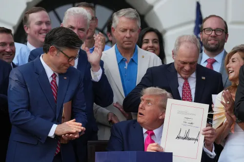 مجموعة من المسؤولين الجمهوريين تحضر توقيع قانون التخفيضات الضريبية من قبل الرئيس ترامب، مع التركيز على ردود الفعل المختلفة حول تأثير هذه السياسات.