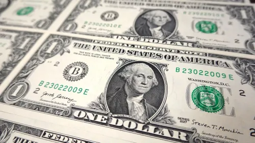 انخفاض الدولار الأمريكي يظهر في صورة لورقة نقدية من فئة الدولار الواحد، مما يعكس حالة عدم اليقين في الاقتصاد الأمريكي وتأثير السياسات التجارية.