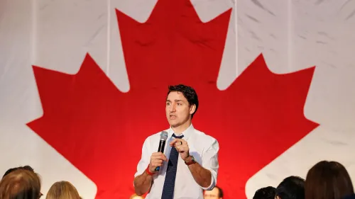 رئيس الوزراء الكندي جاستن ترودو يتحدث في تجمع لرجال الأعمال، مع العلم الكندي خلفه، متناولًا تهديدات ترامب بضم كندا.