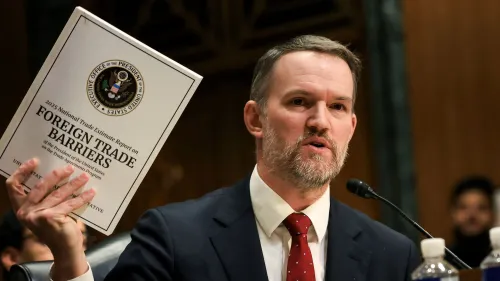 يمسك الممثل التجاري الأمريكي جاميسون جرير بتقرير حول الحواجز التجارية الأجنبية أثناء شهادته أمام لجنة مجلس النواب، حيث يناقش التعريفات الجمركية.