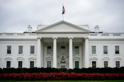 واجهة البيت الأبيض مع أعمدة بيضاء وحديقة مزهرة، تعكس الأجواء الرسمية في ظل مناقشات حول تطبيق TikTok.