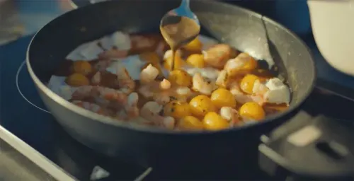 حساء السوكيت الكاتالوني التقليدي يُعد في مقلاة، مع الروبيان وكرات البطاطس، يعكس نكهات البحر الأبيض المتوسط.