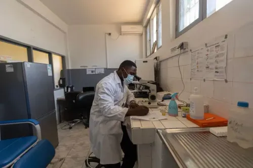 طبيب يرتدي كمامة يعمل في مختبر طبي، محاط بأدوات طبية ومعدات، في سياق جهود مكافحة السل ودعم المرضى.