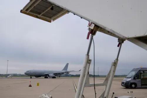 طائرة عسكرية تتواجد على مدرج مطار، مع وجود منصة صعود للركاب في المقدمة، تعكس التوترات حول دعم بريطانيا لإسرائيل.