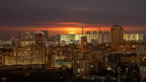 غروب الشمس فوق مدينة كييف، مع ظهور الأضواء في المباني السكنية، يعكس التوترات المستمرة في الصراع الأوكراني الروسي.
