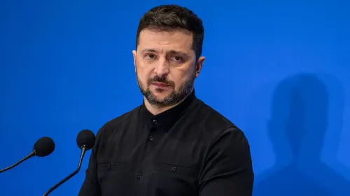 الرئيس الأوكراني فولوديمير زيلينسكي يتحدث خلال مؤتمر صحفي، مع خلفية زرقاء، مع التركيز على دعوته لعقد اجتماع مع روسيا لوقف إطلاق النار.