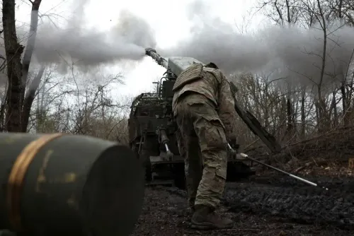 جندي أوكراني يقوم بإطلاق قذيفة من مدفعية في منطقة غابية، مع تصاعد الدخان من المدفع. الصورة تعكس التصعيد في النزاع الأوكراني.