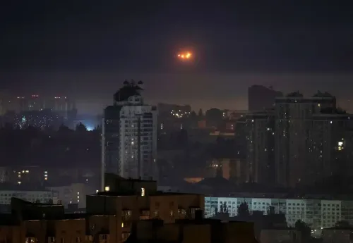 أضواء مشتعلة في السماء فوق مدينة أوكرانية خلال الليل، تعكس تصاعد الهجمات الروسية بالصواريخ والطائرات بدون طيار.