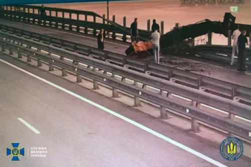 أفراد يقومون بتفقد الأضرار على جسر القرم بعد الهجوم الأوكراني، حيث تضررت أجزاء منه بشكل كبير نتيجة التفجيرات.