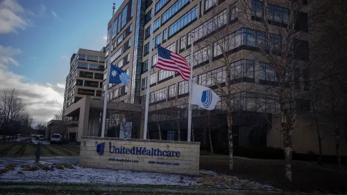 مبنى شركة UnitedHealthcare مع العلم الأمريكي وعلم الشركة، يظهر في خلفية مشمسة. يتناول المقال قضايا قانونية تتعلق بالتشهير.
