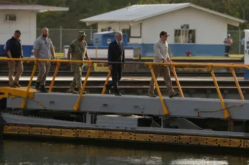زيارة وزير الدفاع الأمريكي إلى قناة بنما، حيث يسير مع وفد رسمي على جسر مطل على القناة، مع وجود مباني خلفية.