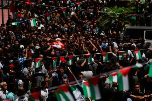 تجمع حشود كبيرة في جنازة سيف الله مسلط، مع رفع الأعلام الفلسطينية، تعبيرًا عن الحزن والغضب بعد مقتله على يد مستوطنين في الضفة الغربية.