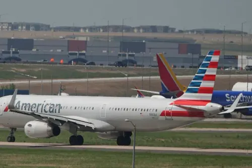 طائرة أمريكية تابعة لشركة الطيران الأمريكية، متوقفة على مدرج في مطار، مع وجود طائرات أخرى في الخلفية، تعكس تأثير الصراع على حركة الطيران في الشرق الأوسط.